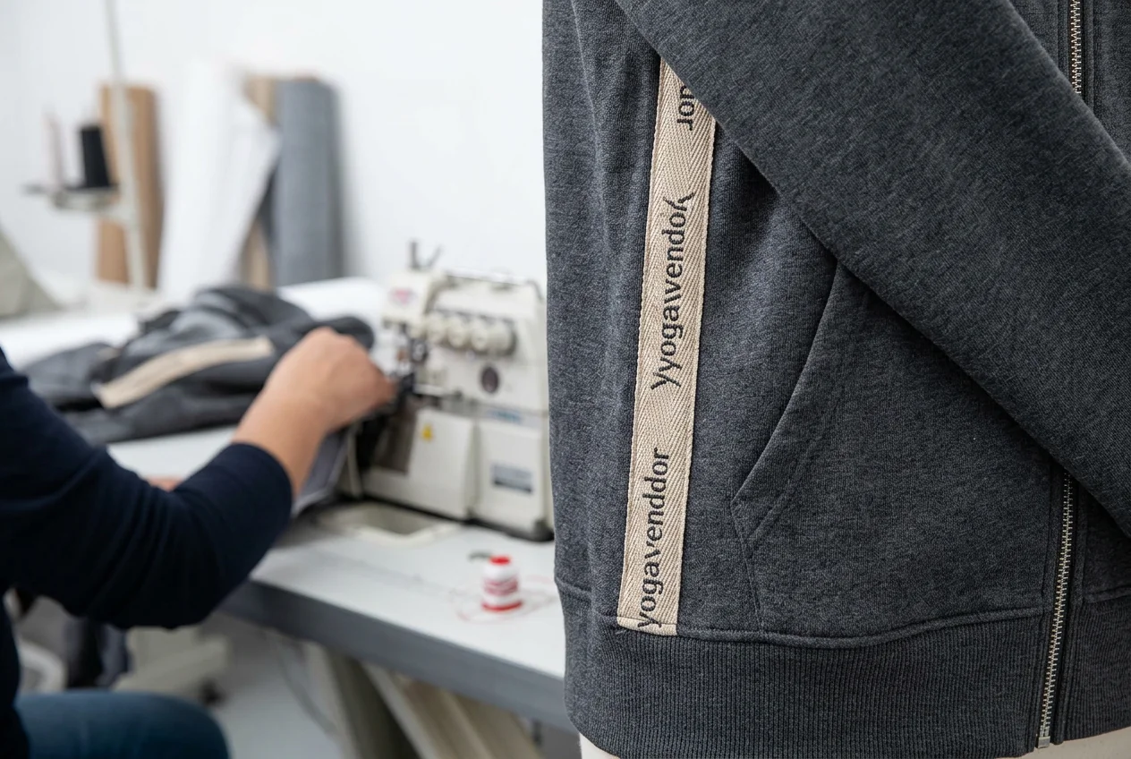 Side-seam woven tape branding on yoga hoodie